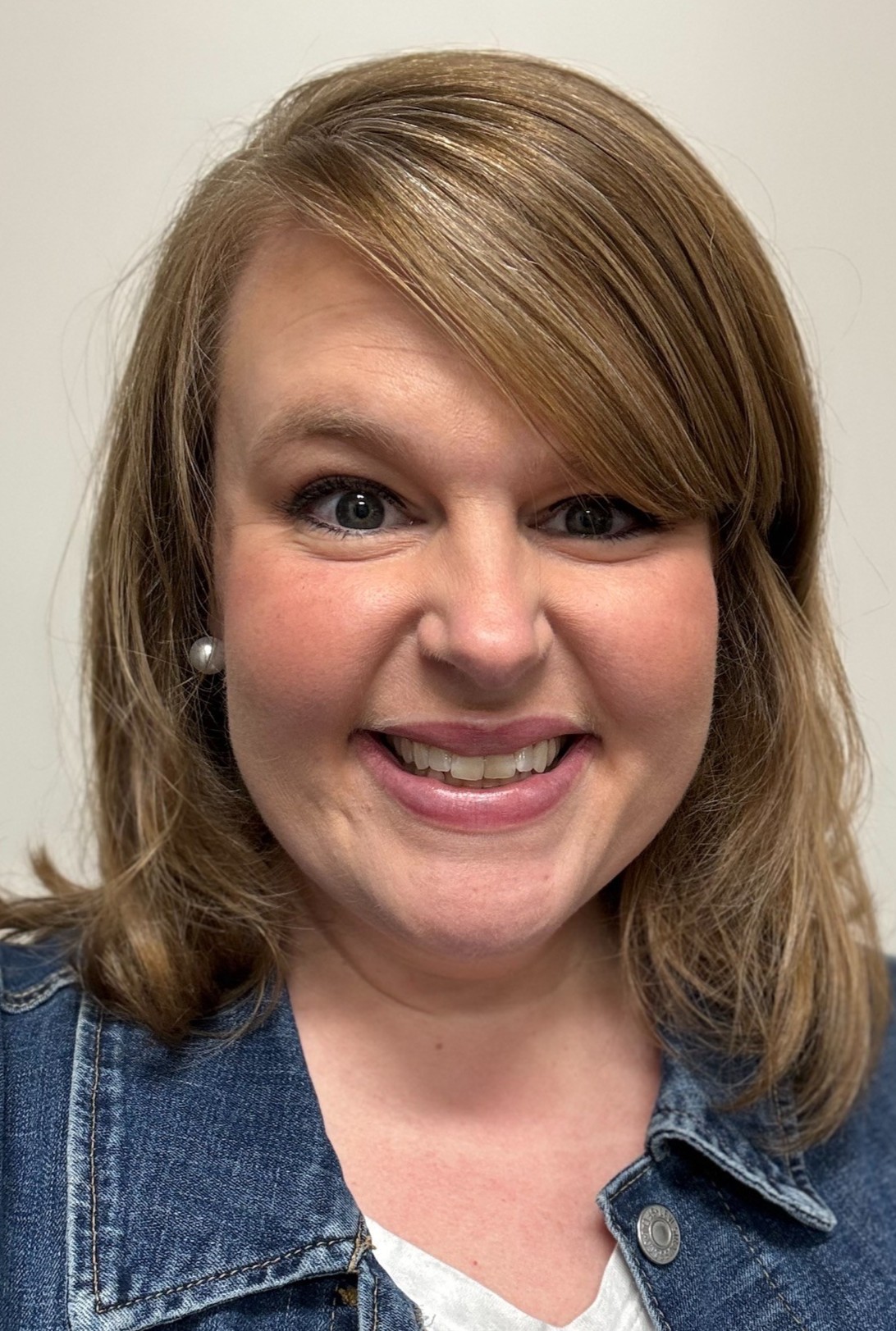 Headshot of Shelby Walker; smiling, set against a neutral background